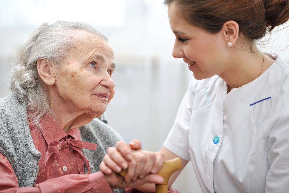 Elderly woman with nurse in nursing home or assisted living